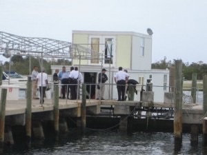Onlookers observe Lozman houseboat moored at Riviera Beach docks.