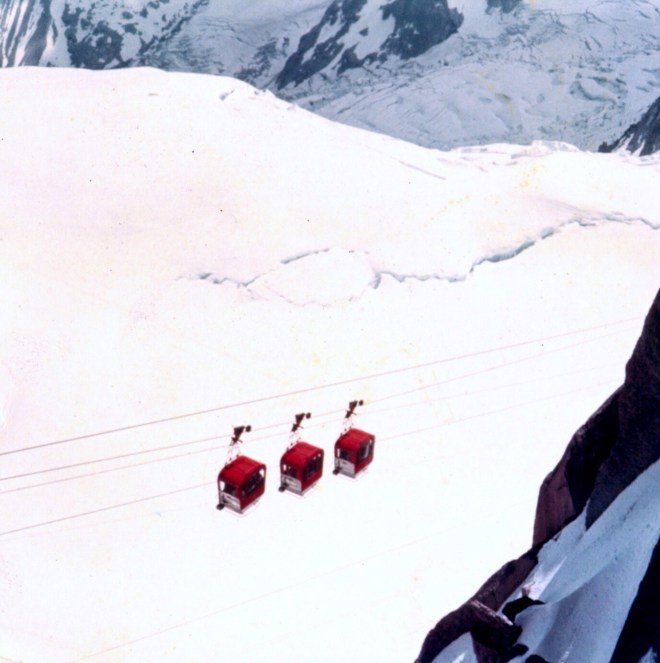 Is three gondola transporting skiers to various stops on Mount Blanc, Chamonix, France? Or is this three maraschino cherries dangling over several scoop of vanilla ice cream?