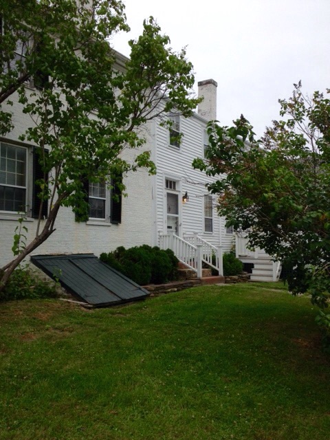 A typical house in Wiscasset or Edgecomb painted in white with green shutters, and connected barn