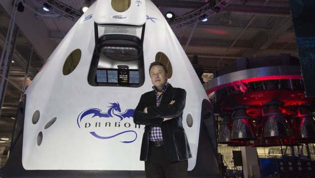Billionaire Elon Musk stands in front of personal space capsule.