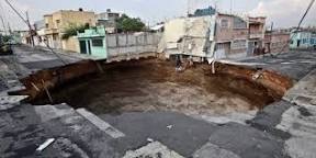 Urban, under asphalt street, near structures.